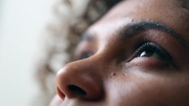 Umut dolu kadın, yakın çekimde gökyüzüne bakıyor.