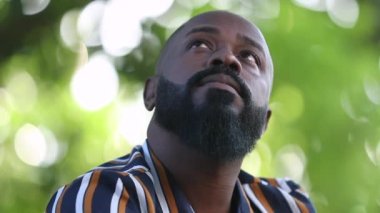 Parkta düşünceli siyah Afrikalı adam.