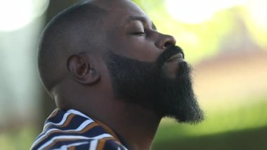 Afrikalı erkek gözleri kapalı yardım ve destek için Tanrı 'ya dua ediyor.