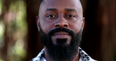 Arkadaş canlısı Afrikalı bir adam kamera önünde gülümsüyor, yakışıklı bir zenci.