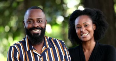 Parkta kameraya gülümseyen iki Afrikalı çift.