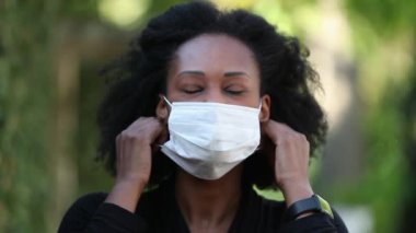 Siyahi kadın maskesini çıkartıyor, rahatlıyor. Afrikalı kadın maskesini çıkarıyor