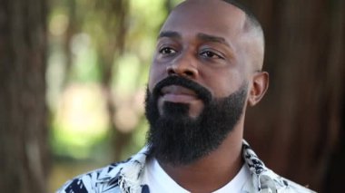 Düşünceli Afrikalı Amerikalı adam dışarıda duruyor.