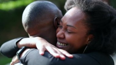 Afrikalı çift birbirlerine sarılıyorlar. Mutlu siyah kadın erkek arkadaşını kucaklıyor.