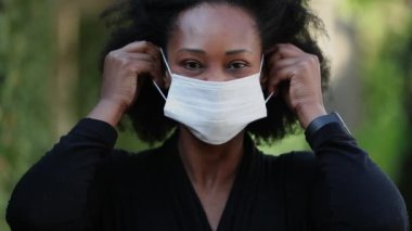 Siyah maske takan Afrikalı bir kadın. Siyahi kadın cerrahi maske takıyor