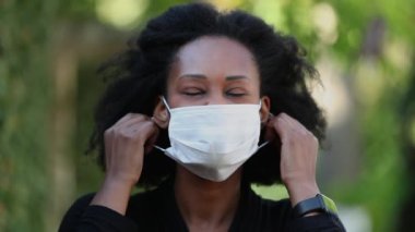 Siyahi kadın maskesini çıkartıyor, rahatlıyor. Afrikalı kadın maskesini çıkarıyor