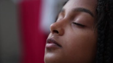 Hispanik siyah çocuk meditasyonda ve tefekkürde gözlerini kapatıyor