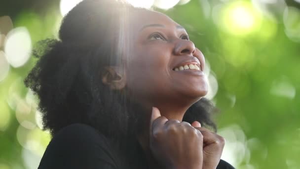 HopeとFaithで空を見て幸せな女性 太陽の光レンズフレア外の精神的なアフリカ人 — ストック動画