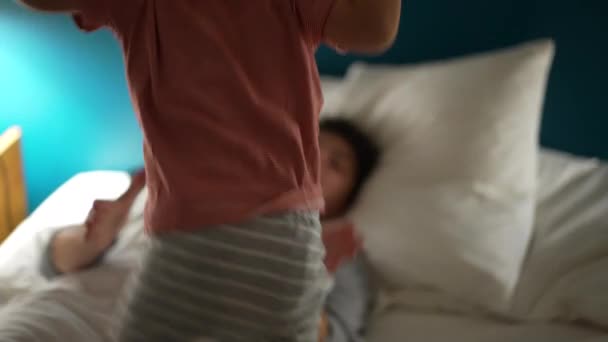 小男孩晚上跳到妈妈床上躺着 孩子晚上跳到妈妈床上 — 图库视频影像