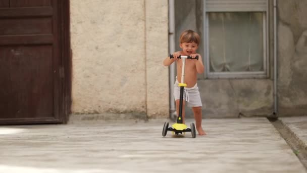 Маленький Хлопчик Їде Іграшковому Скутері Поза Сорочкою Дитина Рівновазі Вправи — стокове відео
