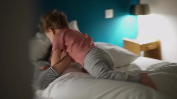 小男孩晚上在床上跳着妈妈 活泼的孩子跳着 — 图库视频影像