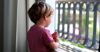 Çocuk bebek ev penceresinden bakıyor