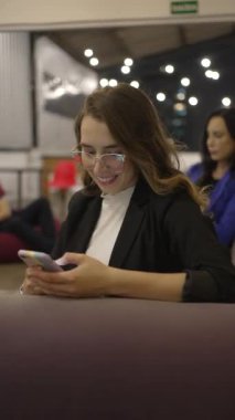 Genç, mutlu bir kadın gece akıllı telefon cihazına mesaj yazıyor. MILlennial yetişkin kız Dikey Video 'da cep telefonu ekranına bakıyor