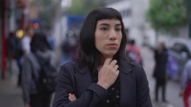 Endişeli genç bir İspanyol kadın sokakta endişeli ve endişeli duruyor. İş kadını Latin, endişe ve meşguliyet hissederken bekliyor.