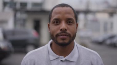 Afrika kökenli Amerikan portresi kameraya yakından bakıyor. Brezilya 'lı bir Güney Amerikalı siyahi sokak ortasında duruyor.