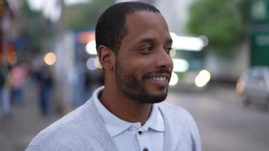 Caddede kameraya gülümseyen mutlu bir zenci portresi. Afro-Amerikalı, yakın çekim yüzü.