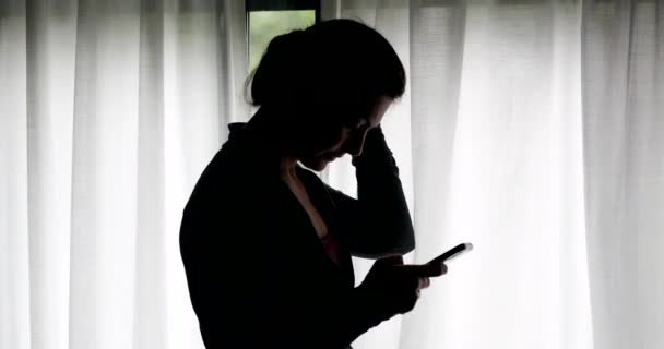 Kvinna Tittar Smartphone Skärm Står Vid Fönstret Silhuett — Stockvideo
