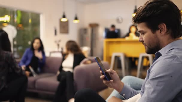 年轻人在工作场所的休息室里看着智能手机装置 在办公室用电话浏览互联网社交媒体的人 — 图库视频影像