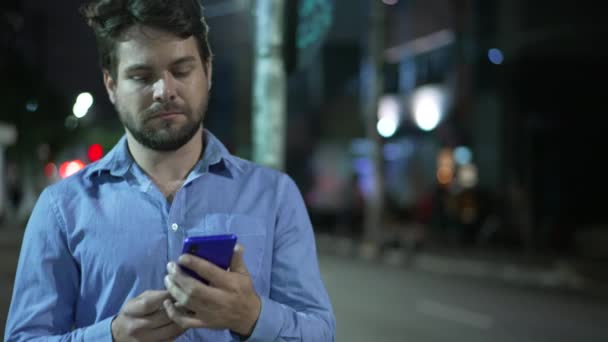 Νεαρός Που Χρησιμοποιεί Τηλέφωνο Ενώ Περπατάει Στο Δρόμο Νύχτα Μήνυμα — Αρχείο Βίντεο