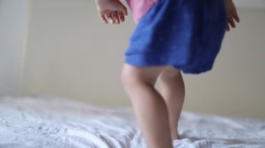 Çocuk yatağa atlıyor. Neşeli oğlan kalkıyor ve zıplıyor