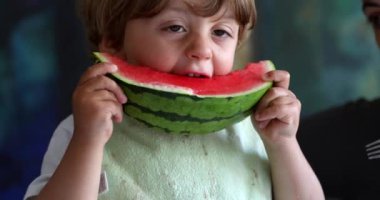 Kırmızı karpuz meyvesi yiyen çocuk, dağınık çocuk sağlıklı yiyecekler yiyor.