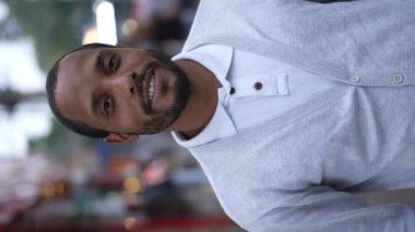 Sokakta dikilip kameraya bakan siyahi bir adamın portresi. Dikey Videodaki Afrikalı bir Amerikalının yakın plan yüzü