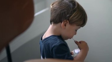 Küçük bir çocuk kaşıkla yoğurt yiyor.