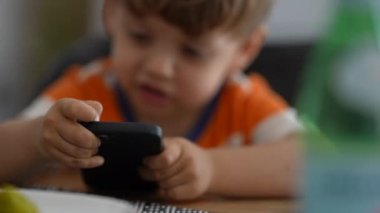 Teknoloji çocuğuna kızgın küçük bir çocuk telefon ekranına çarpıyor ve sinirleniyor.