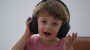 Kulaklık takmış müzik dinleyen küçük bir çocuk.