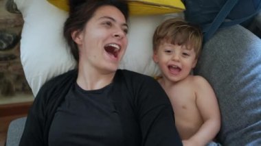 Anne ve çocuk birlikte oynuyorlar. Anne ve bebek kanepede yatıyor.