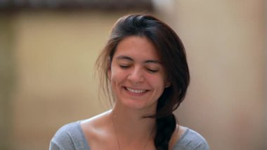 Kameraya bakıp gülen bir kadının portresi..