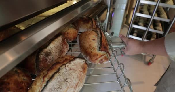 贝克从烤箱里取出面包 堆放在架子上 — 图库视频影像