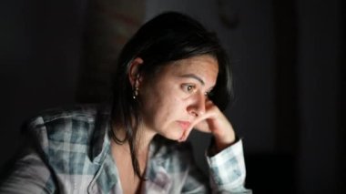 Geceleri dizüstü bilgisayarın önünde içeriği okuyan kişi