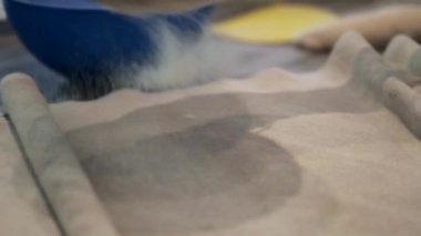 Baker ağır çekimde un yayıyor.