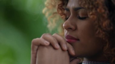 Zenci kadın Tanrı 'ya umutla gökyüzüne bakarak dua ediyor.