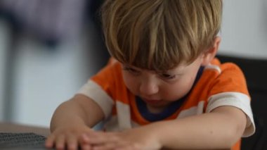 Kızgın küçük çocuk, masaya elleriyle vuruyor.