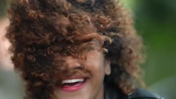 Carefree Λατίνα Μαύρη Γυναίκα Κουνώντας Μαλλιά Και Χαμογελώντας Στην Κάμερα — Αρχείο Βίντεο