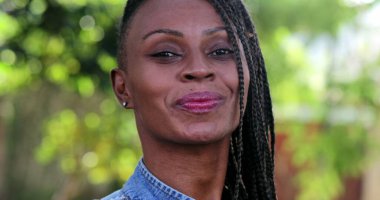 Kendinden emin Afrikalı kadın gülümsüyor, portresi siyah.