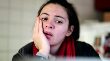 Kadın tepkisi ekranı izliyor. Çevrimiçi içeriğe tepki veren ve etkileşimde bulunan kadınların özgün ve samimi gerçek hayattaki ıstırap ifadesi