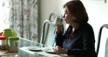 Düşünceli yaşlı kadın sabahları kahve içiyor.