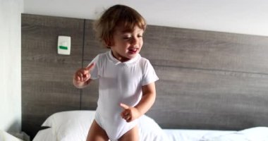 Bebek bebek yatakta balık tutuyor. Çocuk hoplayıp zıplıyor
