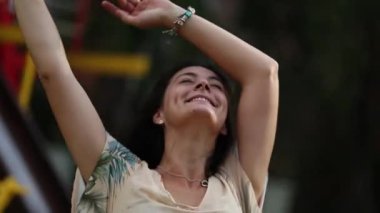 Kaygısız insan dışarıda oyun alanında atlıkarıncada dönüyor kollarını havaya kaldırıyor, özgür bir duygu.