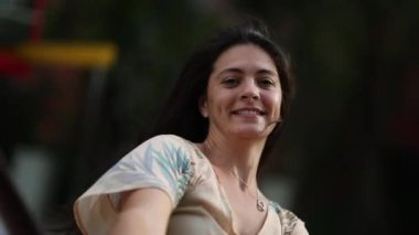 Oyun parkında atlıkarıncada dönen bir kadın. Eğlenceli bir duygu.