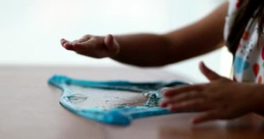 Yakın plan çocuk elleri mavi plastik yapışkanla oynuyor.