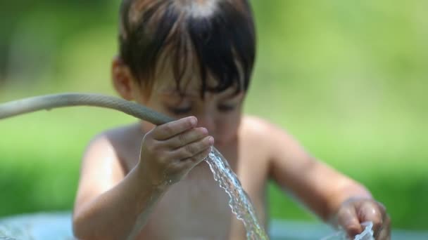 Kleinkind Spielt Sommer Mit Wasserschlauch Eimer Draußen — Stockvideo