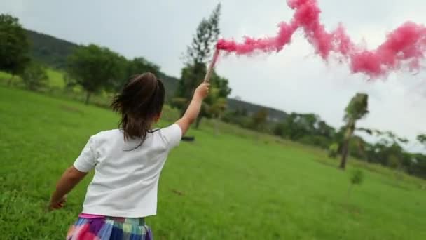 煙棒の信号を持って走っている少女 煙爆弾のお祝い — ストック動画