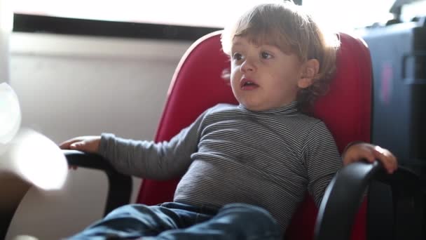 Ξανθό Παιδί Κάθεται Κόκκινη Καρέκλα Βλέποντας Κινούμενα Σχέδια Μέσα — Αρχείο Βίντεο