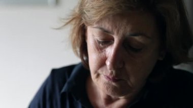 Çiğneme ve yeme yaşlı kadın portresi. Yaşlı kadın yüz yeme dalgın rahat yakın çekim