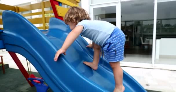 蹒跚学步的男孩爬上游乐场滑梯 — 图库视频影像