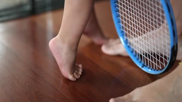 Baby Steht Zehenspitzen Und Hält Tennisschläger — Stockvideo